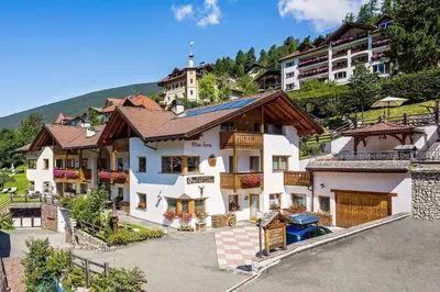 a large white house in front of a mountain at Cesa Sara in Ortisei