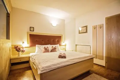 a bedroom with a bed with two slippers on it at Cesa Sara in Ortisei