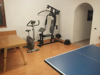 a room with two exercise bikes and a table at Cesa Sara in Ortisei
