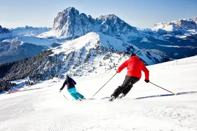 two people skiing down a snow covered mountain at Cesa Sara in Ortisei