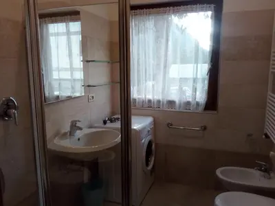 a bathroom with a sink and a washing machine at APPARTAMENTO VALENTINI in Campitello di Fassa