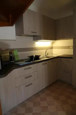 a kitchen with wooden cabinets and a sink and a stove at APPARTAMENTO VALENTINI in Campitello di Fassa