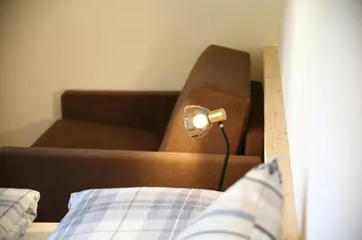 a bed and a chair with a lamp in a room at Ferienwohnungen Unterangerhof in Quinzo