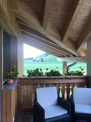two chairs on a porch with a view of a field at Ferienwohnungen Unterangerhof in Quinzo