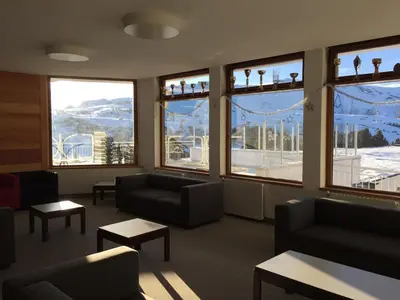 a waiting room with couches and tables and windows at Appartamento Alpe di Siusi in Alpe di Siusi