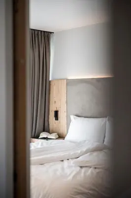 a bedroom with a white bed with a head board at Mühlwaldhof Appartement in Fiumes