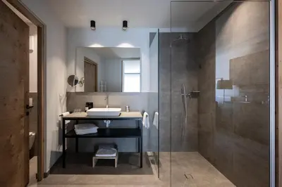 a bathroom with a glass shower and a sink at Mühlwaldhof Appartement in Fiumes