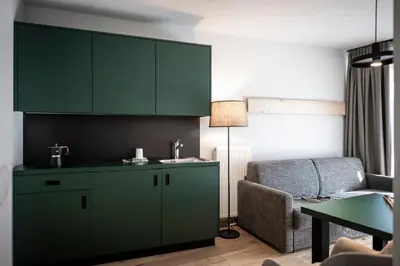 a living room with green cabinets and a couch at Mühlwaldhof Appartement in Fiumes