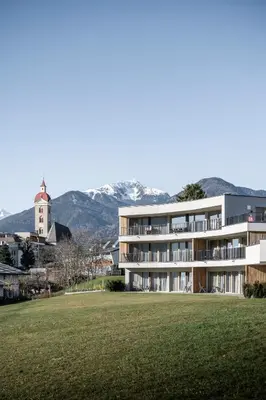 a large building with a grass field in front of it at Mühlwaldhof Appartement in Fiumes