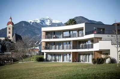 a white building with mountains in the background at Mühlwaldhof Appartement in Fiumes
