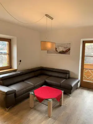 a living room with a leather couch and a table at Appartment Valentin in Chiusa