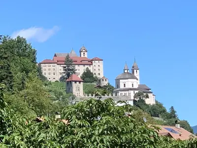 a castle on top of a hill with trees at Appartment Valentin in Chiusa
