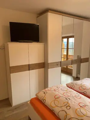 a bedroom with a bed and a flat screen tv at Appartment Valentin in Chiusa