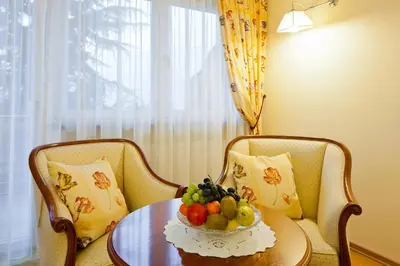 a bowl of fruit on a table with two chairs at Hotel Aster in Merano