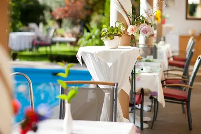 a table with plants on it next to a pool at Hotel Aster in Merano