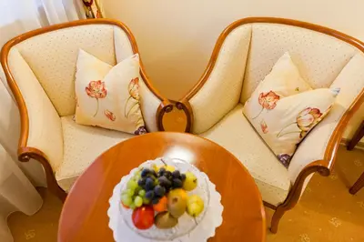 a plate of fruit on a table on a chair at Hotel Aster in Merano