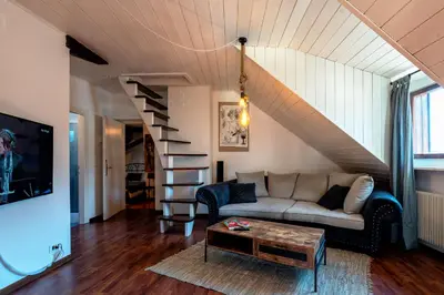 a living room with a couch and a staircase at Il Florino Maia in Merano