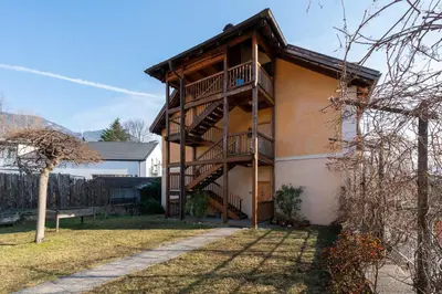 a house with a wooden staircase on the side of it at Il Florino Maia in Merano