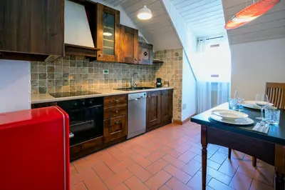 a kitchen with wooden cabinets and a table with plates on it at Il Florino Maia in Merano
