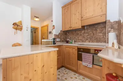 a kitchen with wooden cabinets and a sink at Miralago in Alleghe