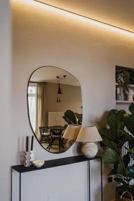 a mirror on top of a dresser in a living room at meralino boutique apartment in Merano