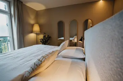 a bedroom with a large bed with white sheets and pillows at meralino boutique apartment in Merano