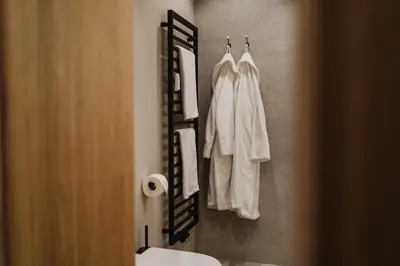 a bathroom with white towels hanging on a wall at meralino boutique apartment in Merano