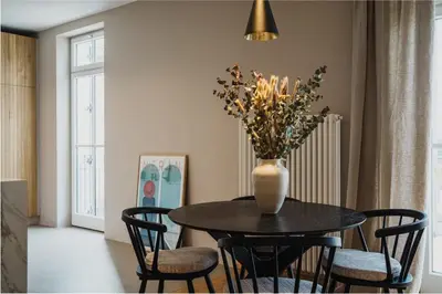 a dining room table with a vase of flowers on it at meralino boutique apartment in Merano