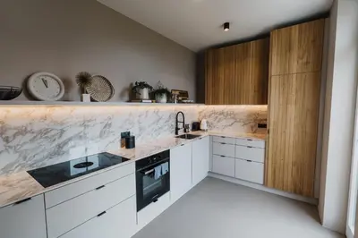 a kitchen with white cabinets and marble counter tops at meralino boutique apartment in Merano