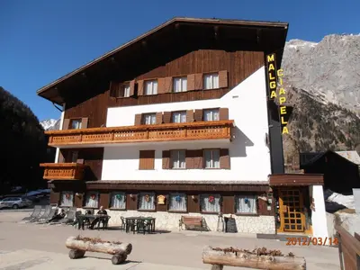 a large building with tables in front of it at Albergo Malga Ciapela in Rocca Pietore
