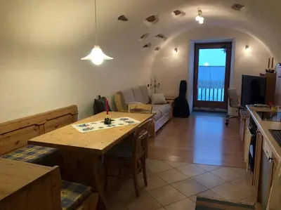 a table with flowers on it in front of a door at CASA DIAF appartamento incantevole Carano Ville di Fiemme in Carano