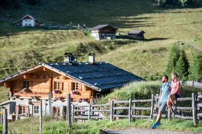 two people standing on a fence in front of a house at Haus Bernhard in Schenna
