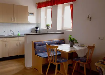 a kitchen with a table and two chairs and a table at Haus Bernhard in Schenna