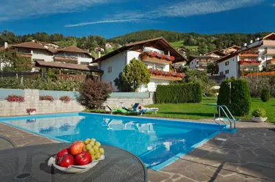 a bowl of fruit on a table next to a swimming pool at Haus Bernhard in Schenna