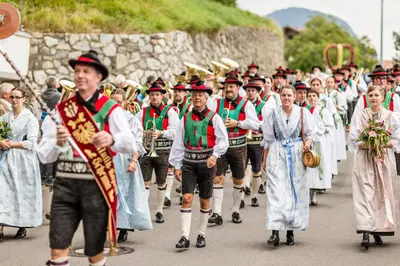 a group of people in traditional costumes walking down a street at Haus Bernhard in Schenna