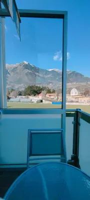 a table and a chair in a room with a window at Apartment mit Tiefgarage 8 Min zu Fuß bis ins Zentrum in Merano