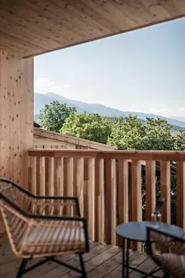 a balcony with a chair and a table and a view at Stadl Chalet oberhalb Brixen in Rosa