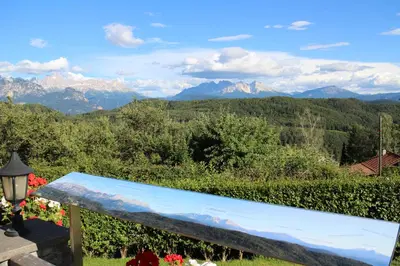 a blue bench with mountains in the background at Hotel Regina in Soprabolzano