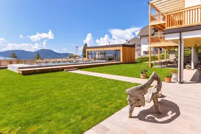 a statue of a horse on a lawn in front of a building at Hotel Regina in Soprabolzano