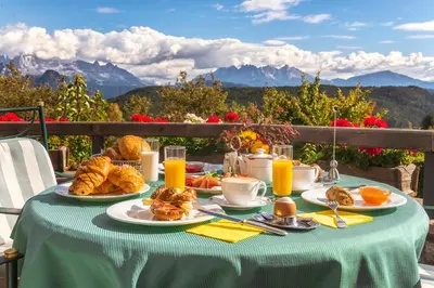 a table with a breakfast of croissants and orange juice at Hotel Regina in Soprabolzano