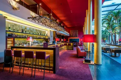 a bar in a restaurant with tables and chairs at Hotel Therme Meran - Terme Merano in Merano