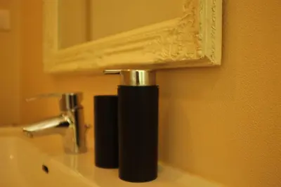 a bathroom sink with a faucet and a mirror at La Vista - Apartment mit Traumblick & Garten in Marlengo