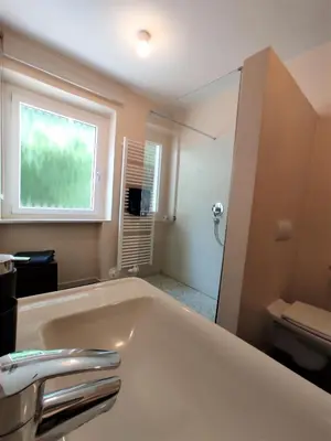 a bathroom with a tub and a toilet and a window at La Vista - Apartment mit Traumblick & Garten in Marlengo