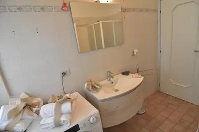 a bathroom with a tub and a sink and a mirror at Appartamento Da Romina con parcheggio gratuito in Sanzeno