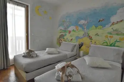two beds in a room with a mural on the wall at Appartamento Da Romina con parcheggio gratuito in Sanzeno