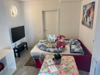 a room with two beds and a table and a tv at Franz home Wi-Fi AC 1 free parking in Bolzano