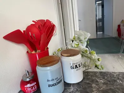 two canisters sitting on a counter with red utensils at Franz home Wi-Fi AC 1 free parking in Bolzano