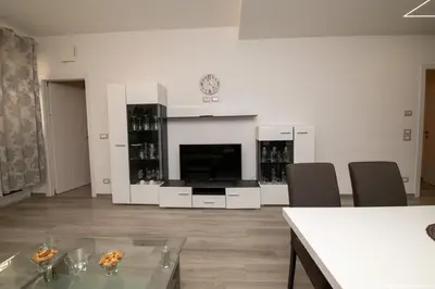 a living room with a television and a table and chairs at Imperial Deluxe in Merano