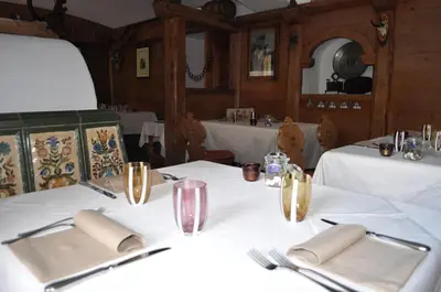 a table with white napkins and utensils on it at Baita Fraina in Cortina dʼAmpezzo