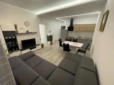 a living room and kitchen with a couch and a table at Junior Deluxe 2 in Merano